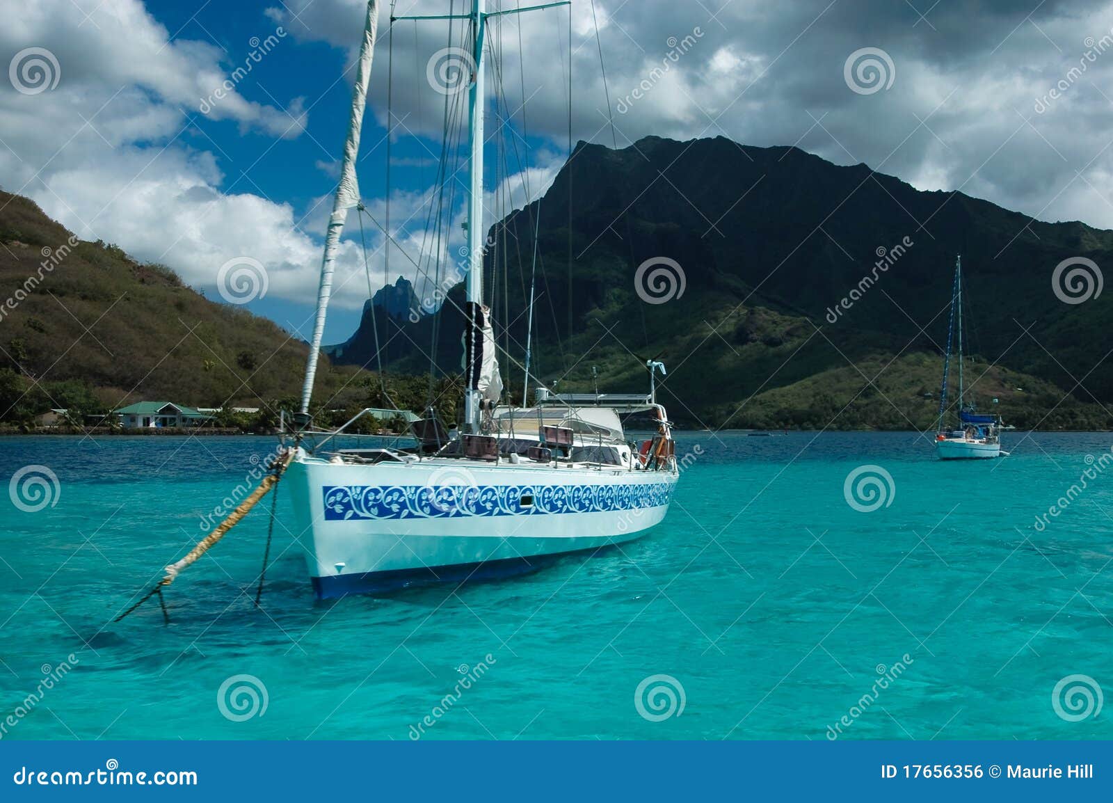 Charter yacht lies at anchor on the aqua blue Tahitian lagoon, in 