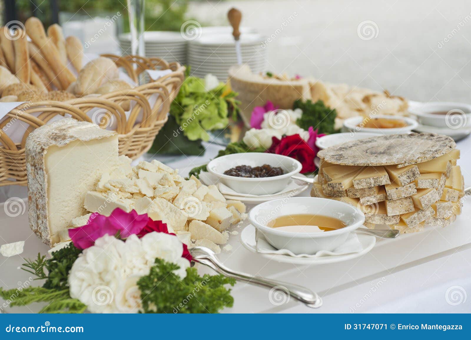 Buffet table with cheese, honey and jam.