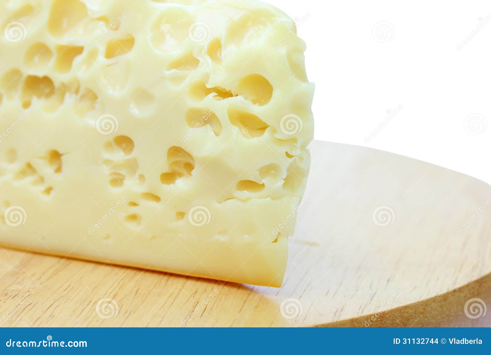 Yellow cheese on wooden cutting board.