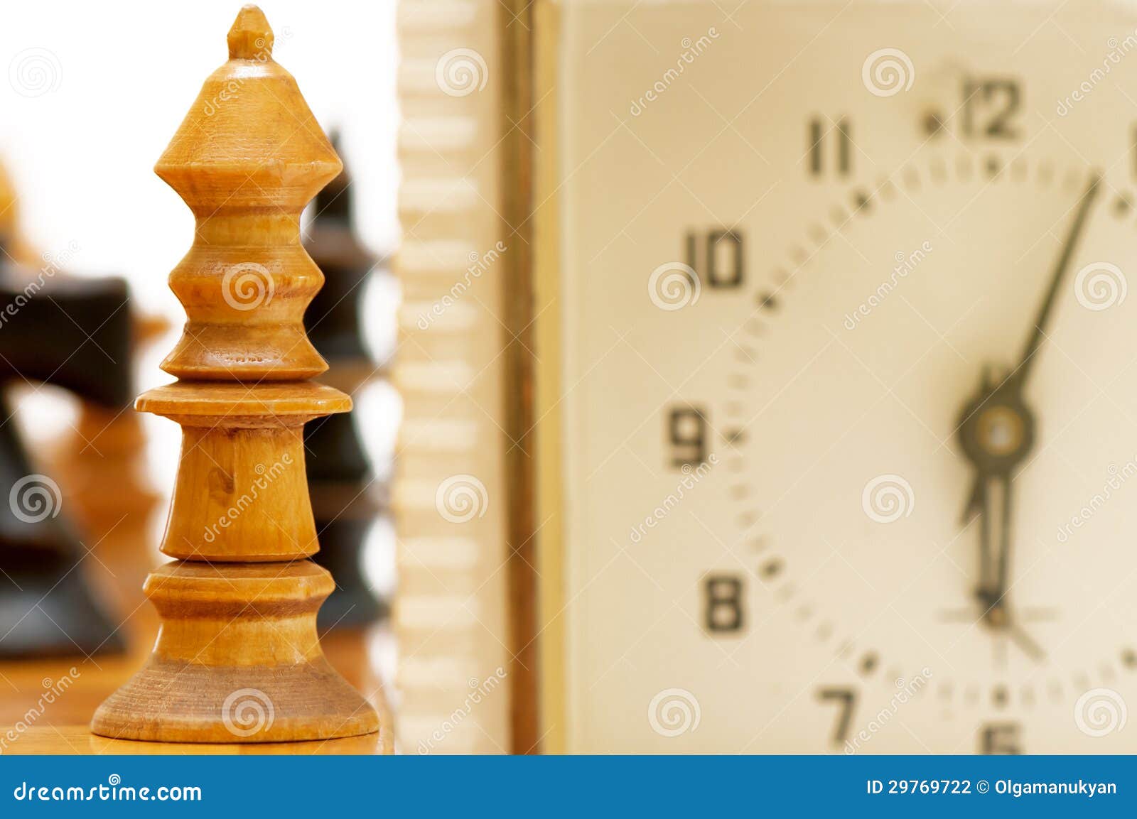 Chess timer with chess game figures on board in background.