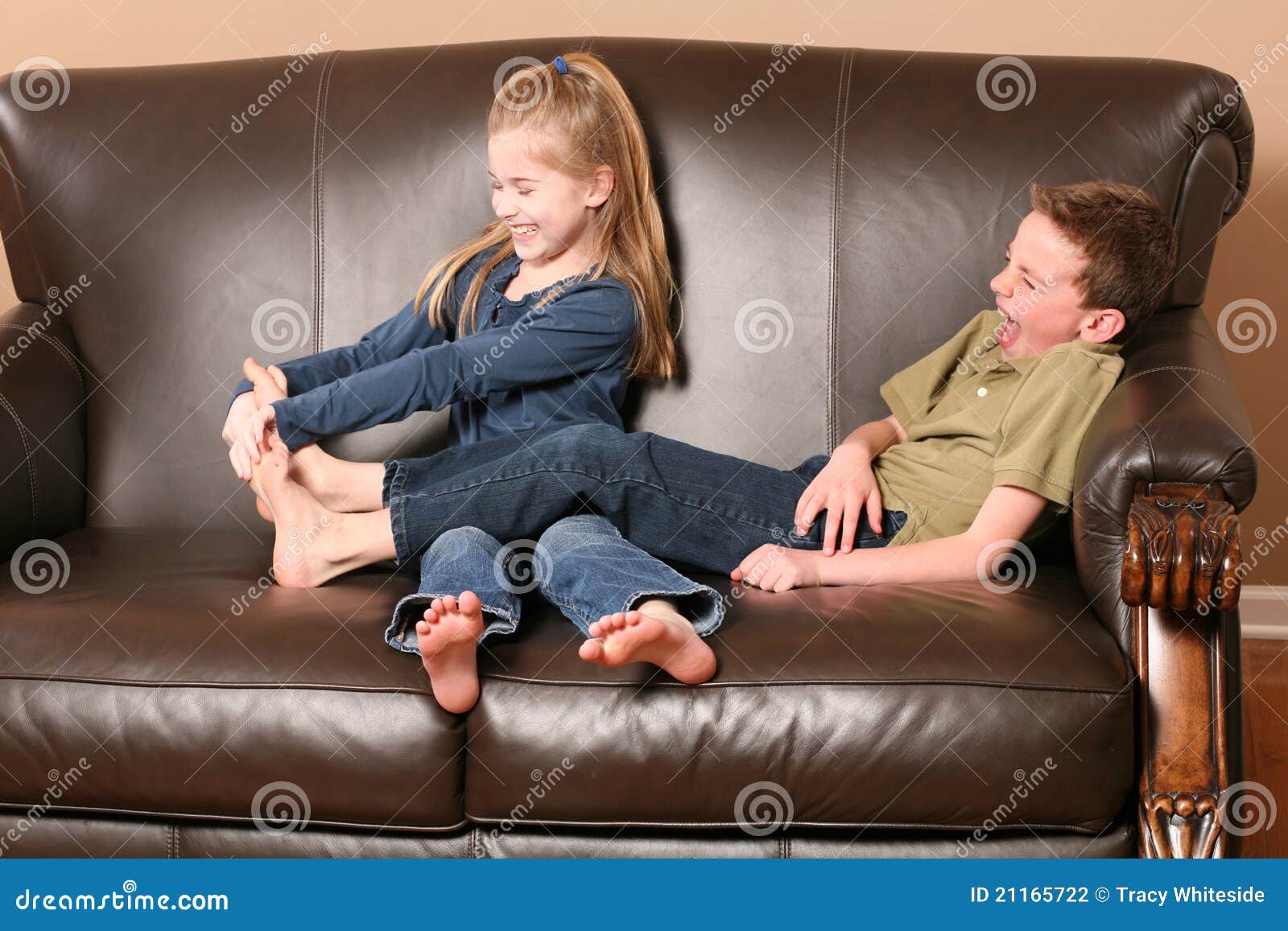 Cute little girl tickling brother's feet.