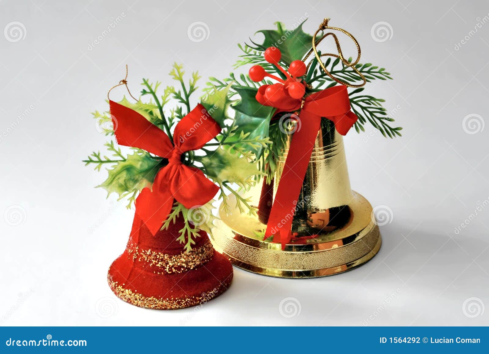 Two Christmas bell decorations with holly, mistletoe and ribbons ...