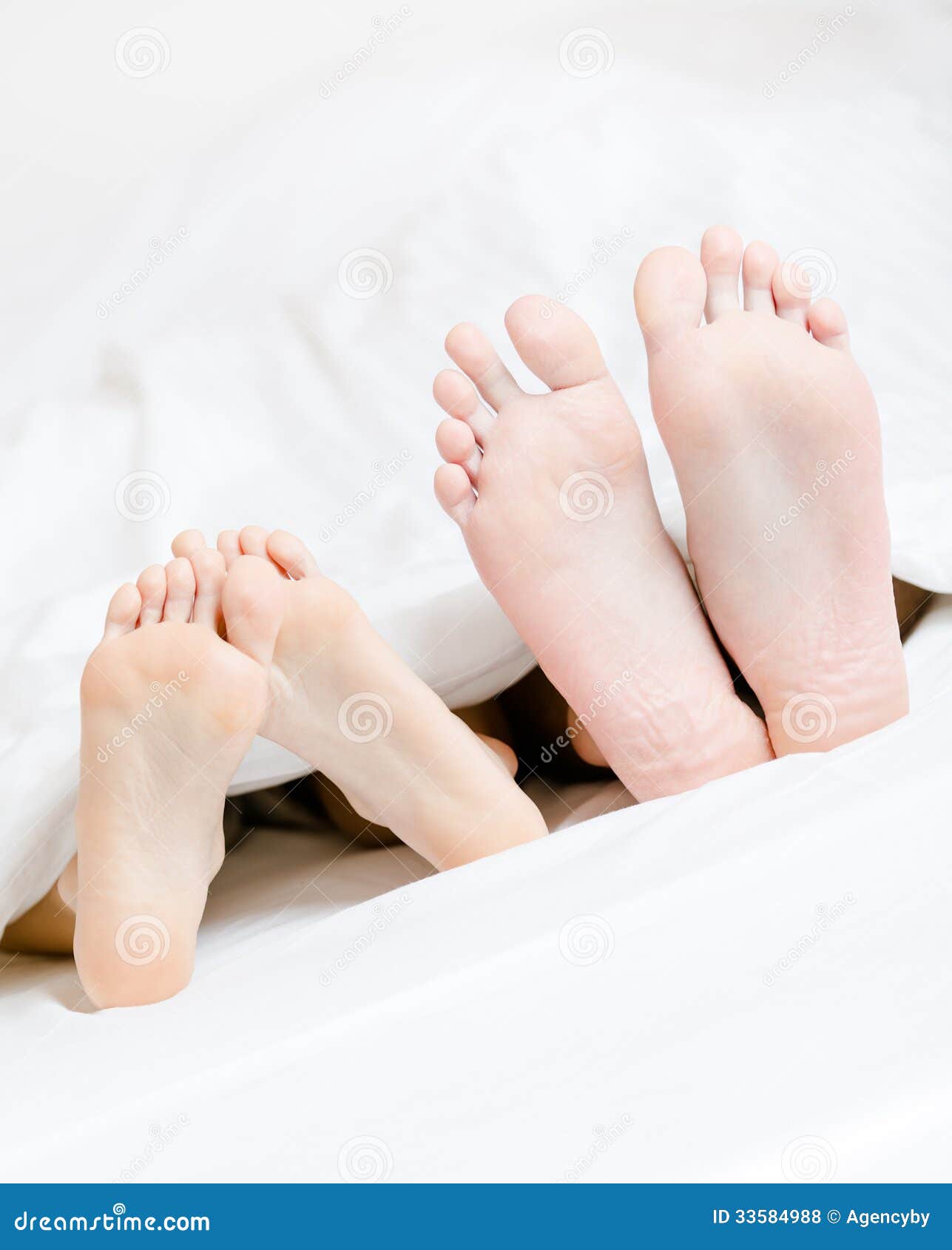 Close Up Of Feet Of The Couple Lying In Bed Royalty Free Stock Photos