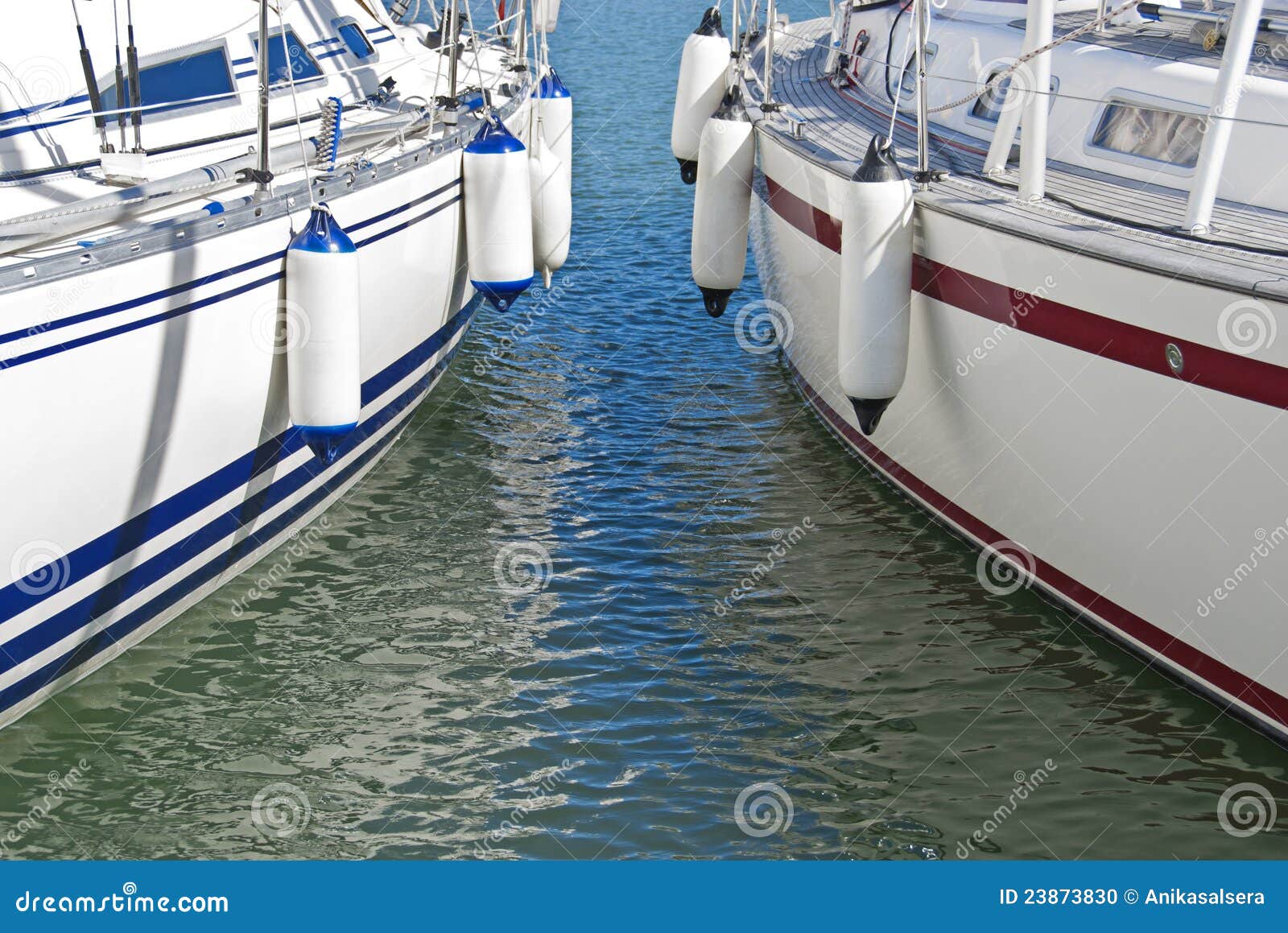 Two colorful motorboats with fenders on calm water parked in the 