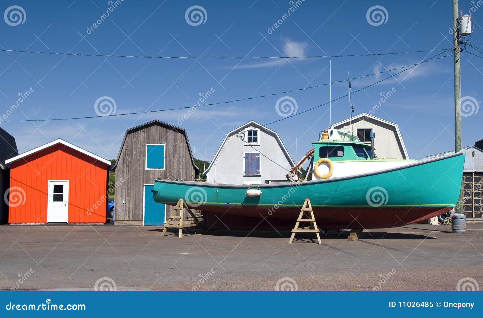 Commercial lobster boat outside colorful bait sheds prior to launching 