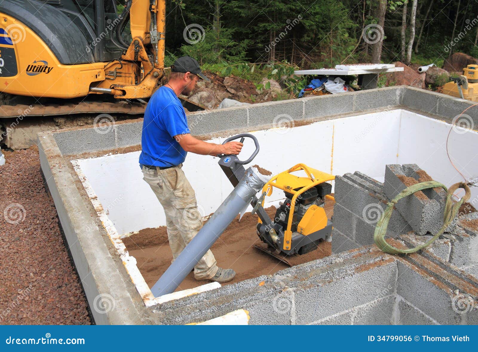  - construction-worker-plate-compactor-man-compacts-sand-sauna-foundation-34799056