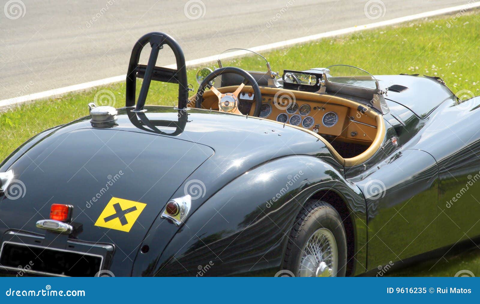 Closeup of a classic convertible sports car parked close to a racing 