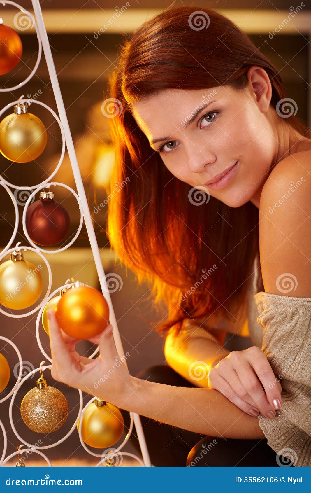 Cosy christmas portrait of smiling beauty by modern christmas tree 