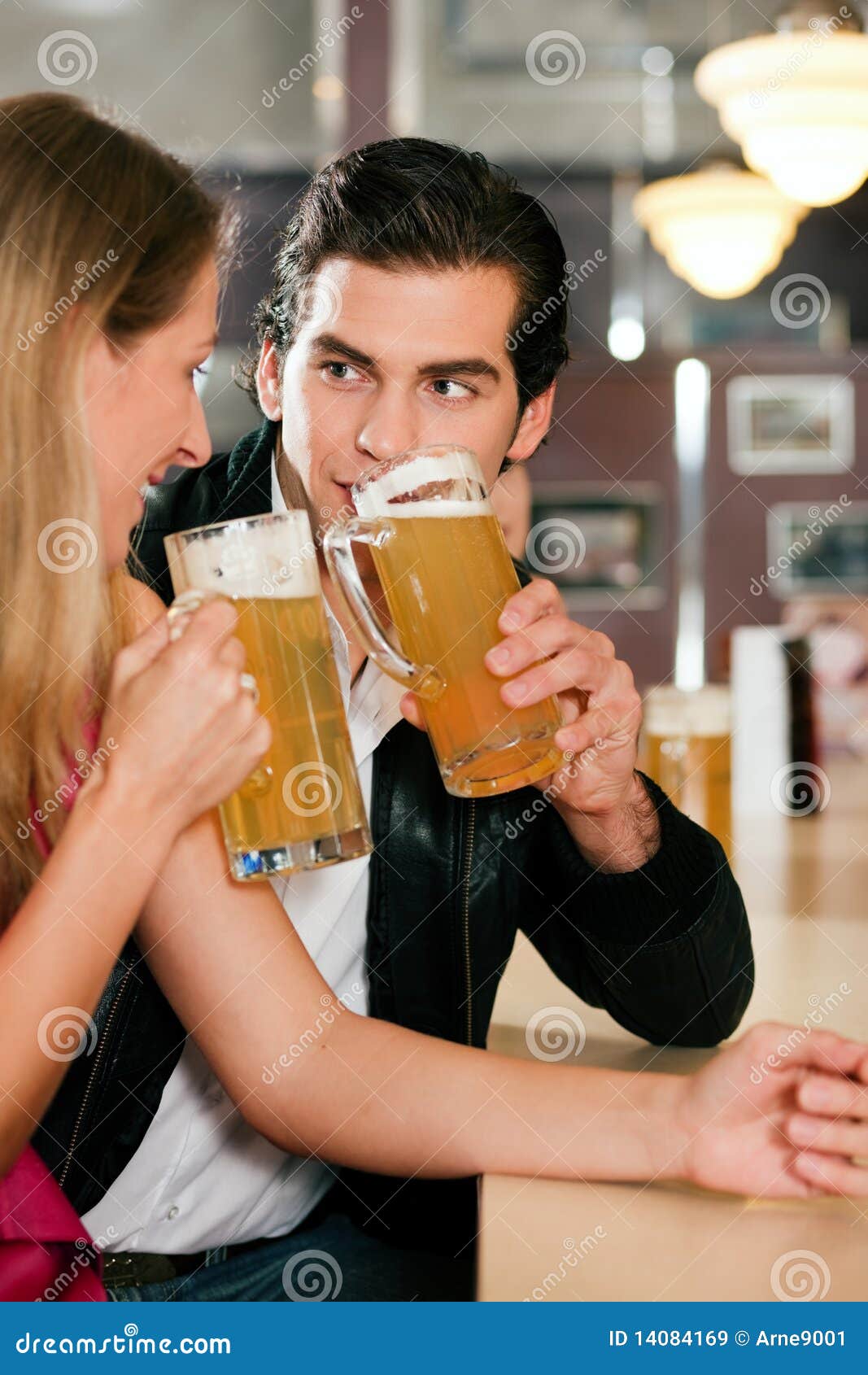 Couple In Bar Drinking Beer Flirting Royalty Free Stock Images