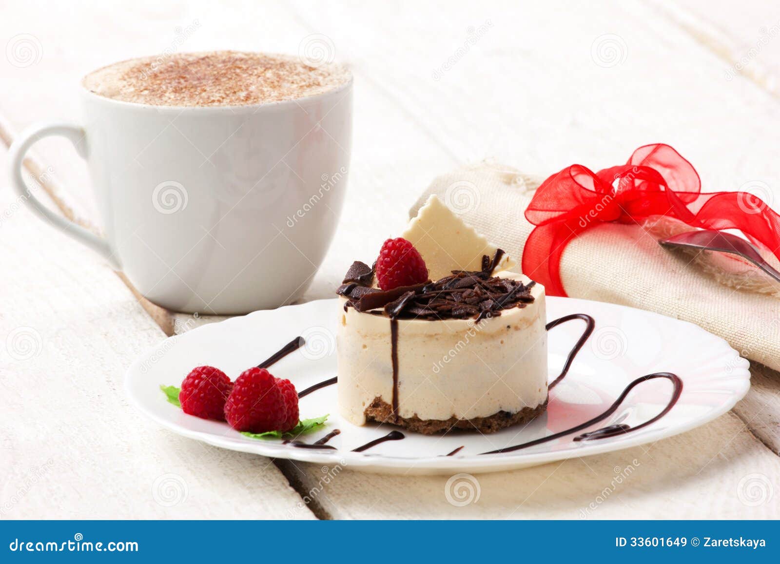 Coffee with cream and cup-cake with raspberry and chocolate in white 