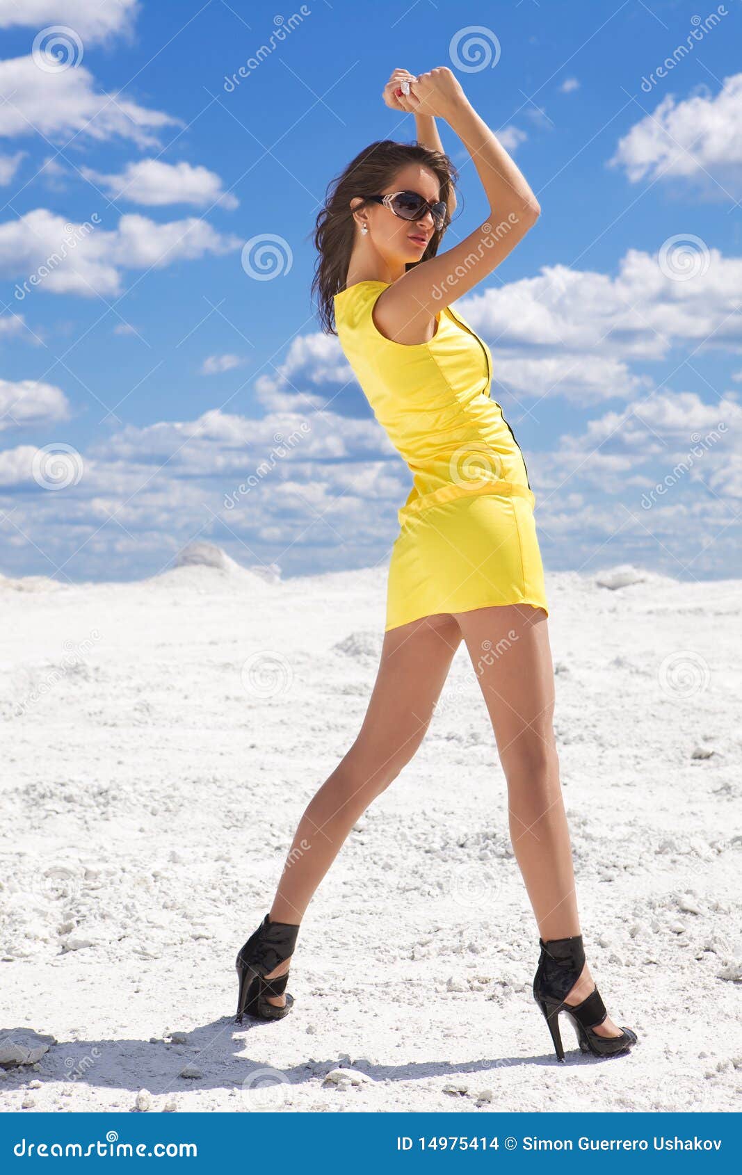 Cute young woman in yellow dress on the snow sexy.