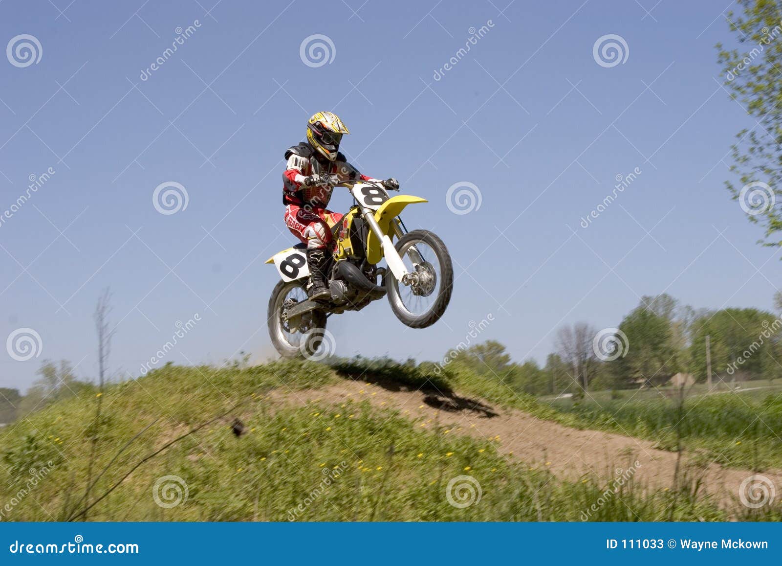 dirt bike racer jumping a hill at a dirt bike race.