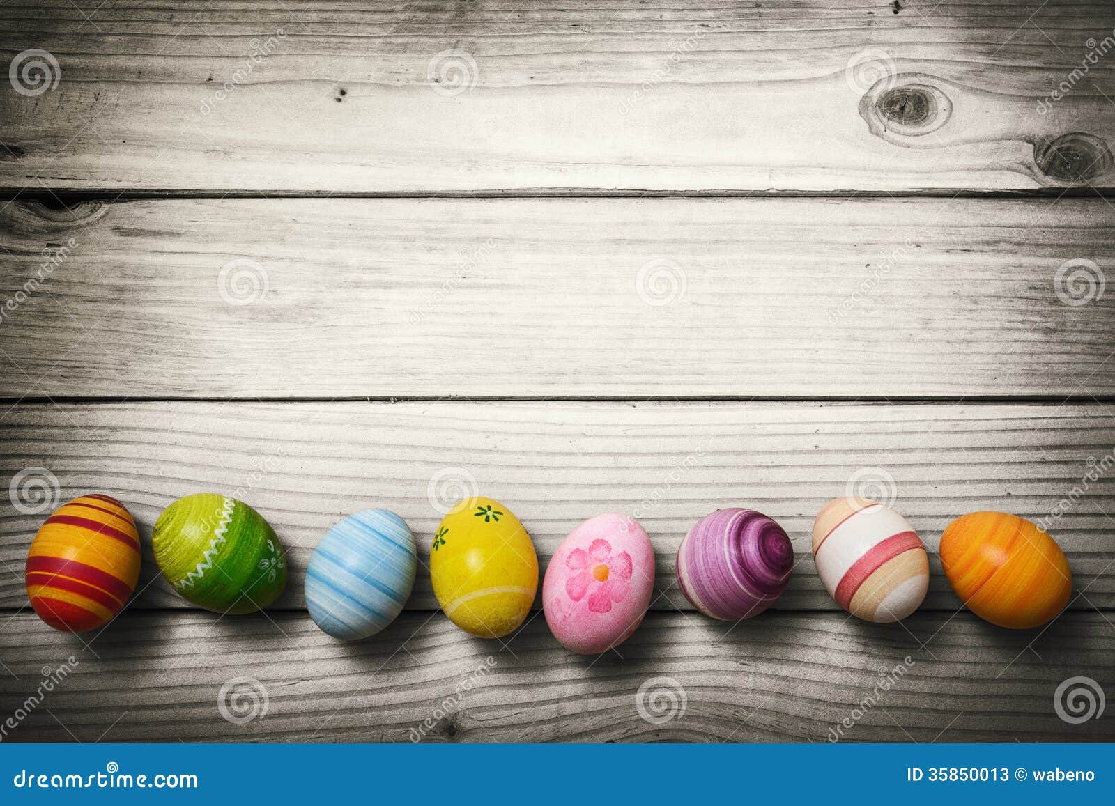 Hand painted colorful Easter eggs on rustic wooden planks.