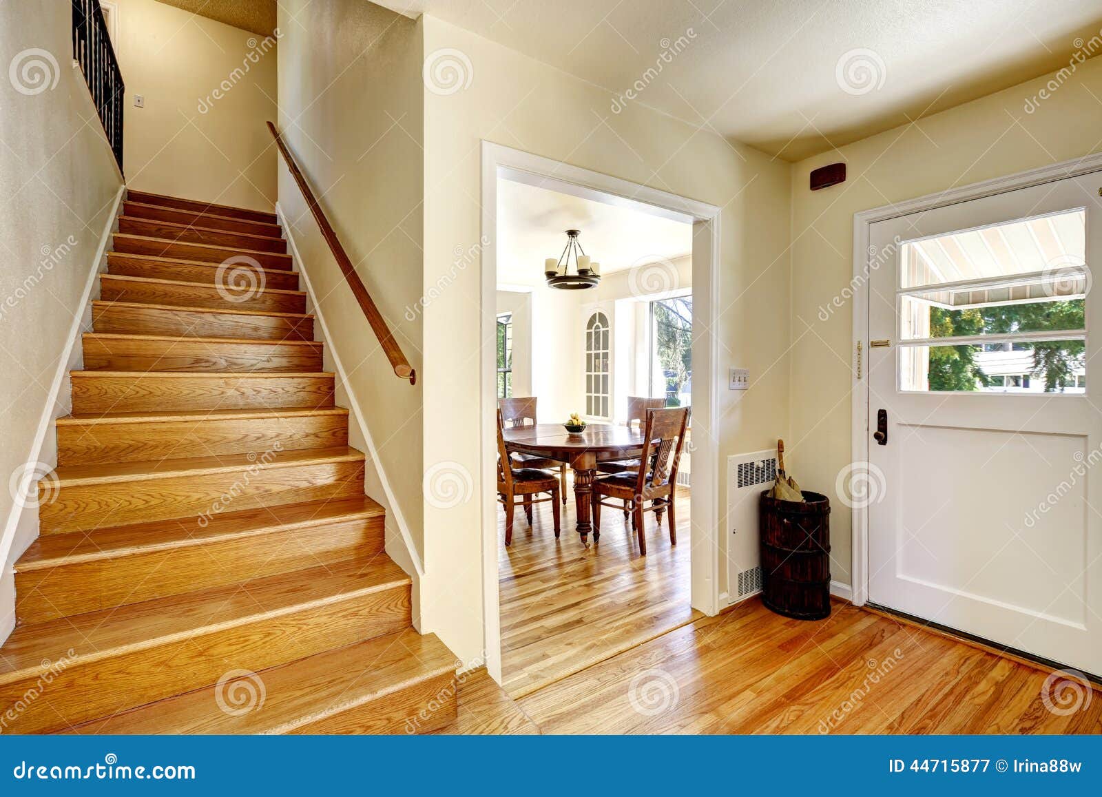 Entance empty hallway with hardwood floor and wooden staircase.
