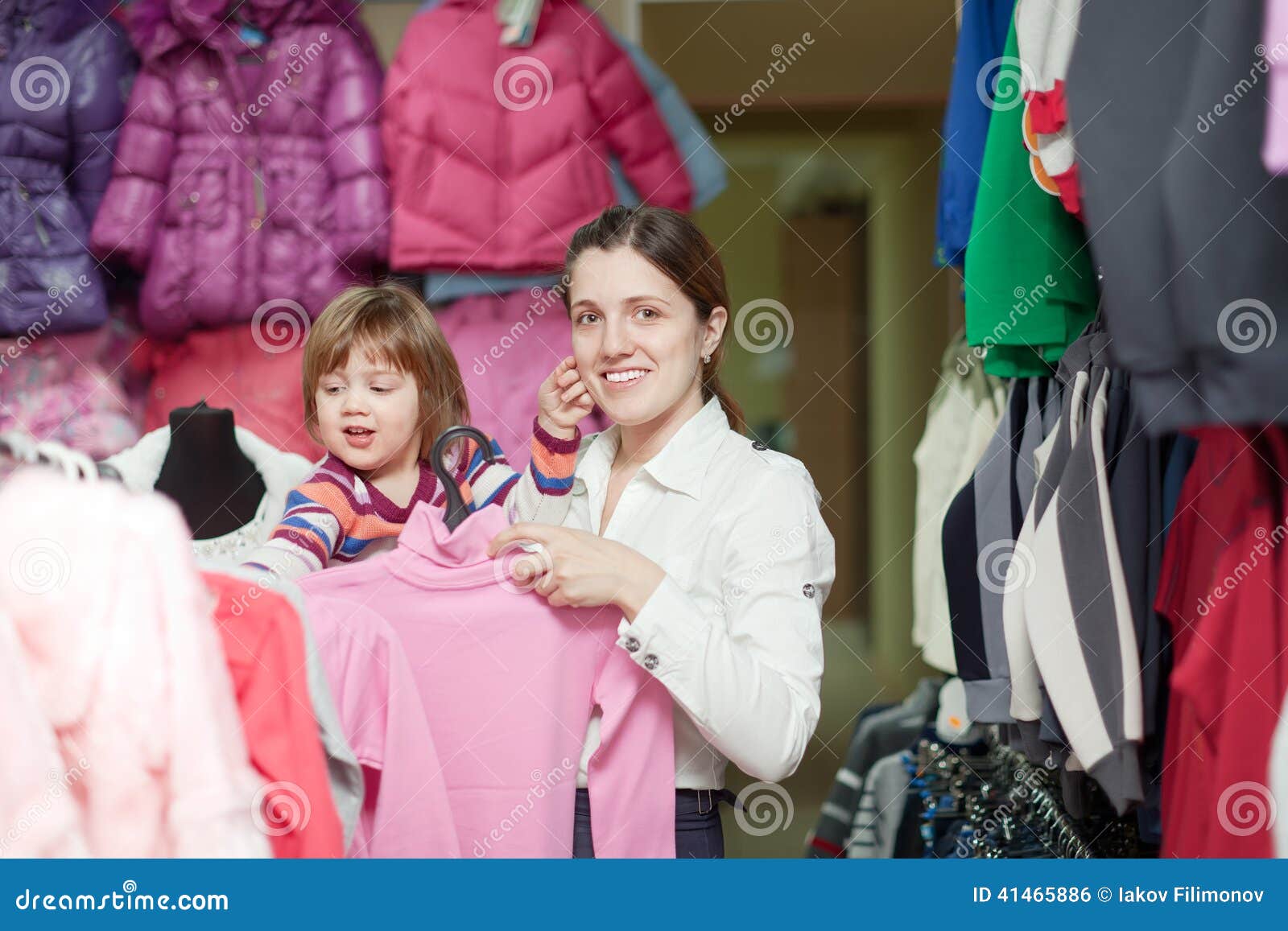 Stock Photo - family with twio children and pregnant mother in Clothes store