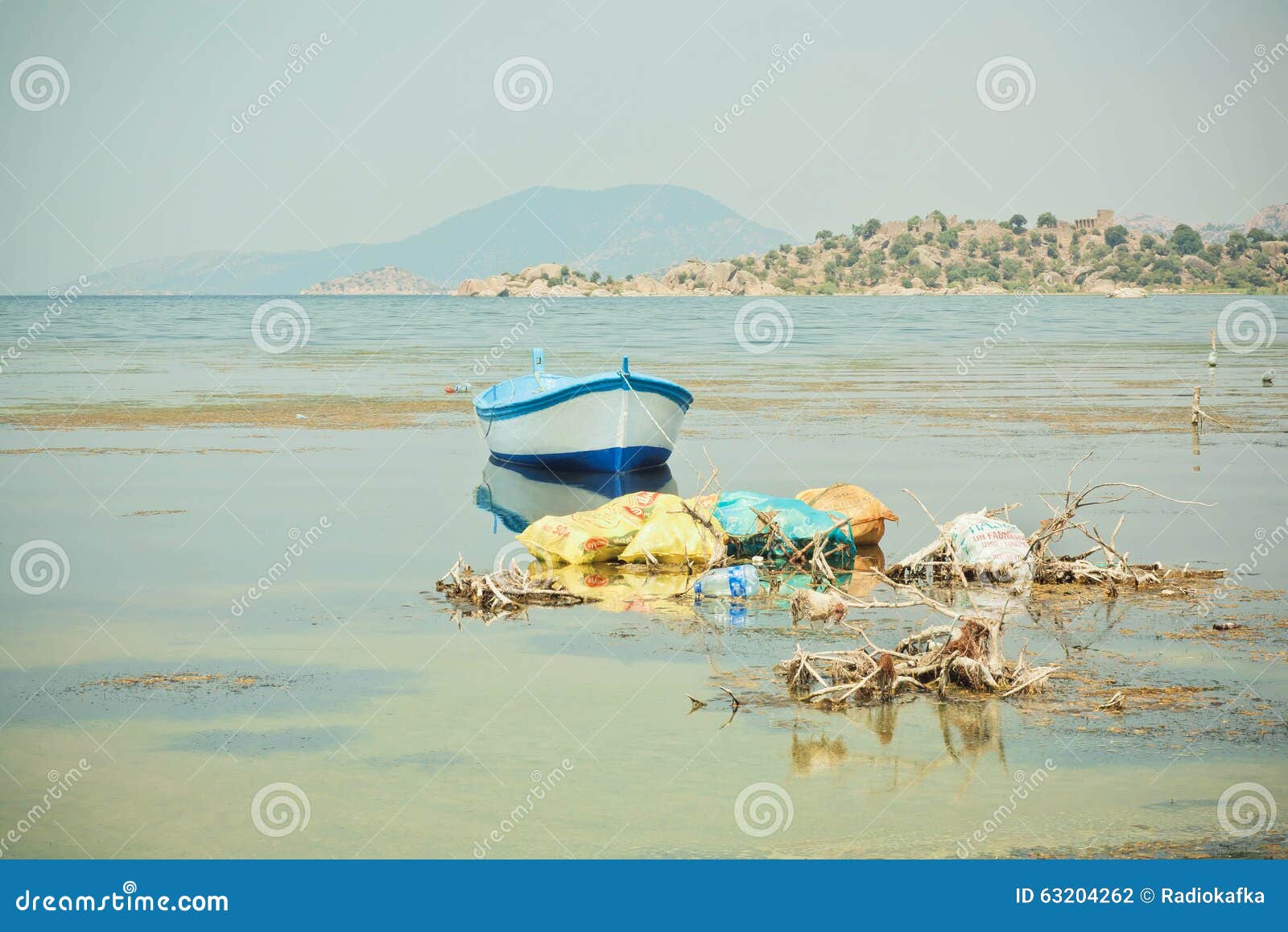  boat on the water of drying lake Bafa with pollution by garbage