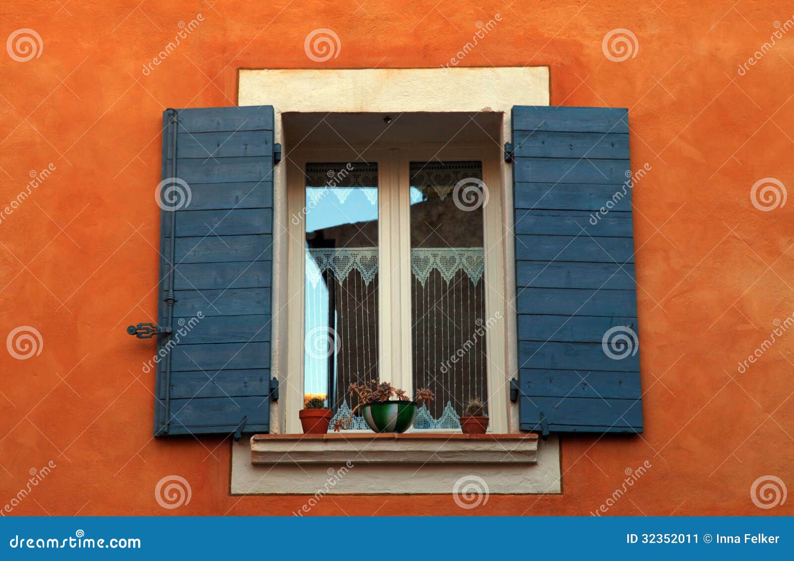 Old french open window with blue shutters in red rural house, Provence Old french open window with blue shutters in red rural house, Provence