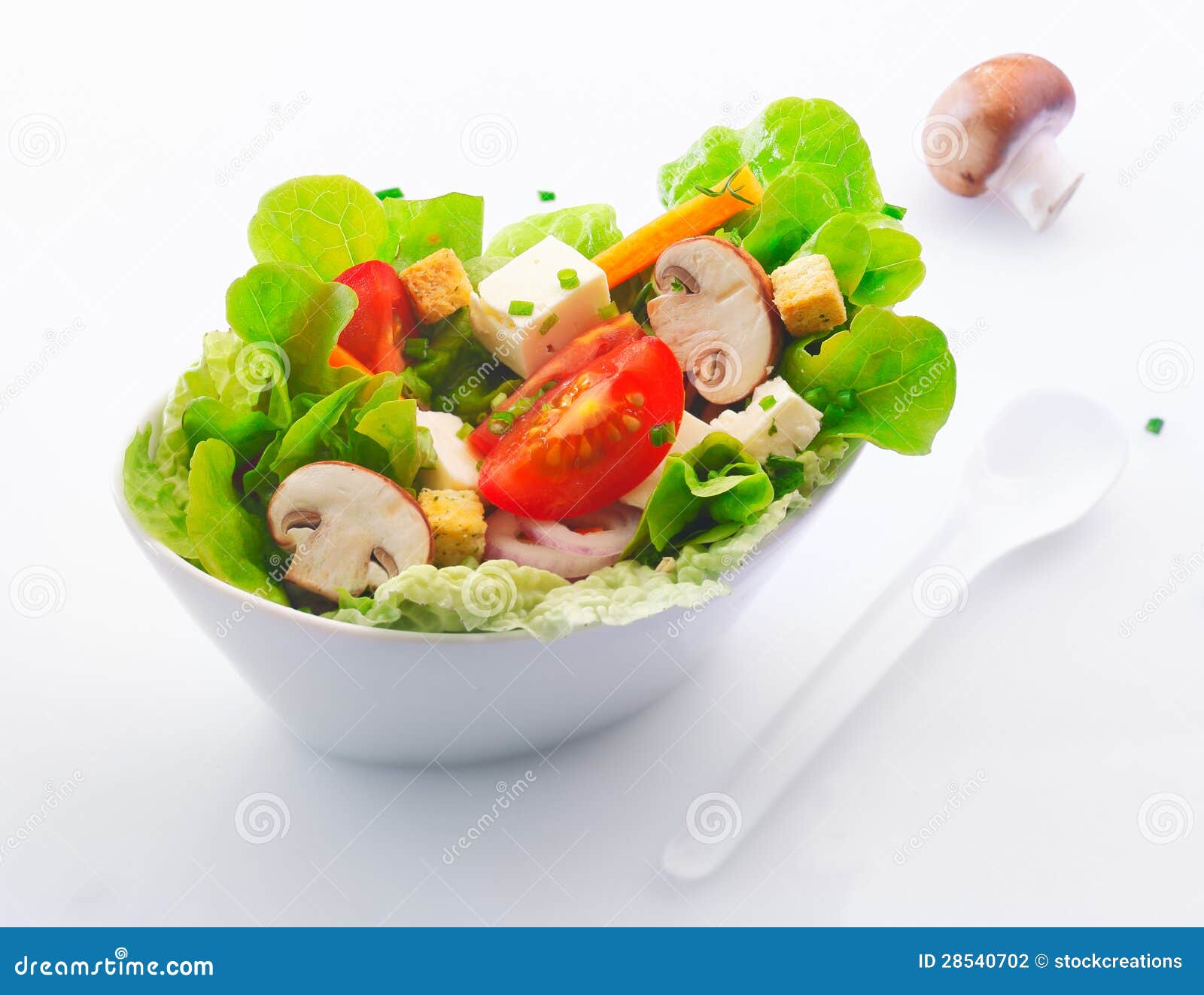 in a white china dish of fresh mixed green salad with sliced fresh ...
