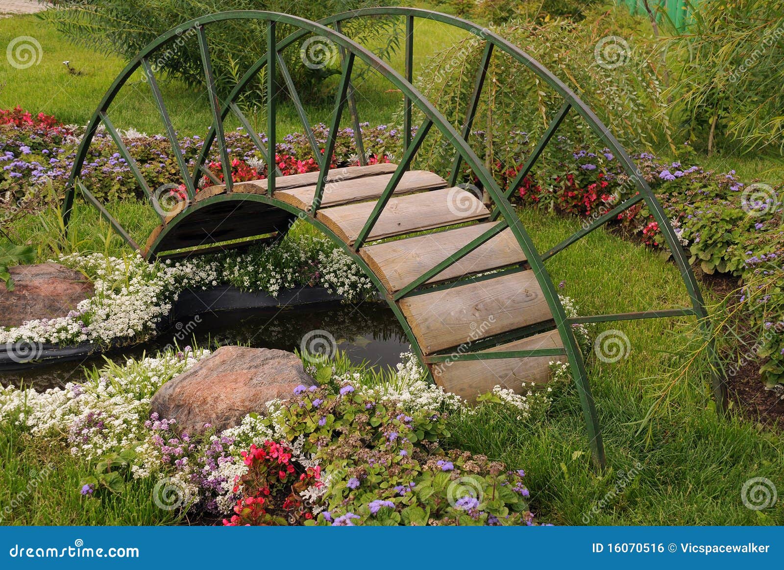 Garden arched bridge, little artificial pond and flowers in the garden ...