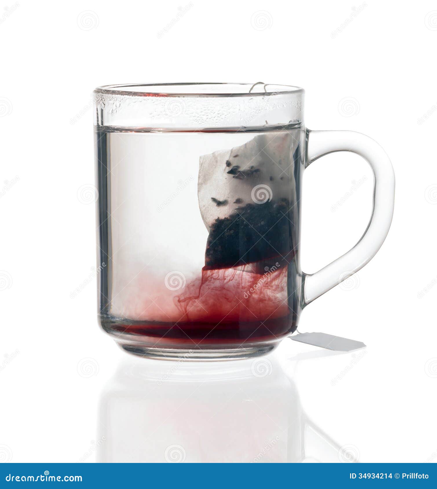 Transparent glass teacup including reddish fluid with tea bag, on ...
