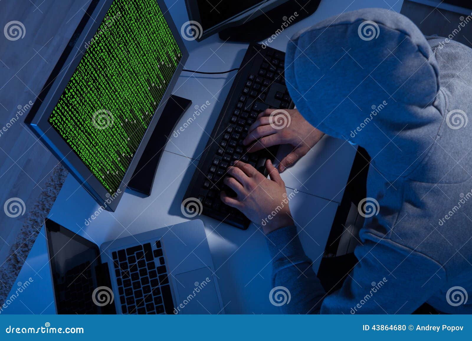 Hacker In Hooded Jacket Using Computer At Table Stock Photo - Image: 43864680