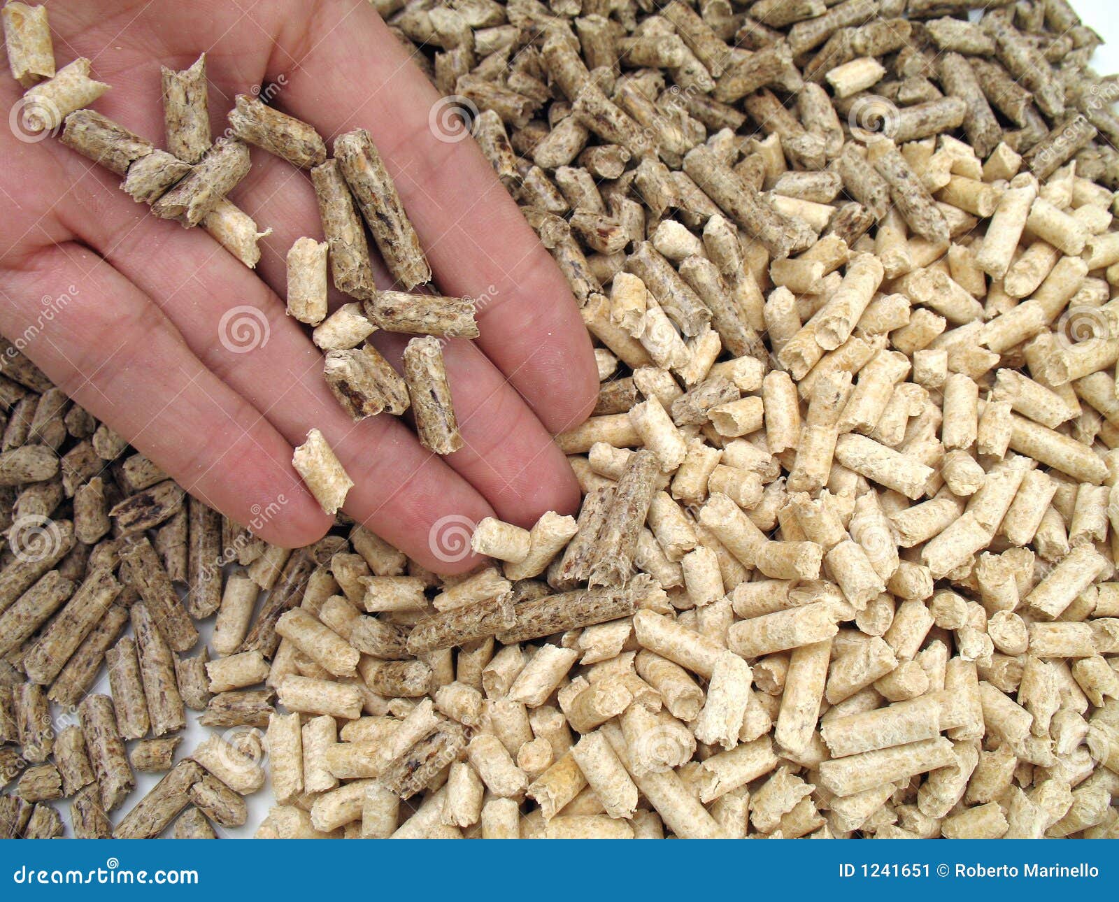 Hand's giving wood pellets for fireplaces and stoves.
