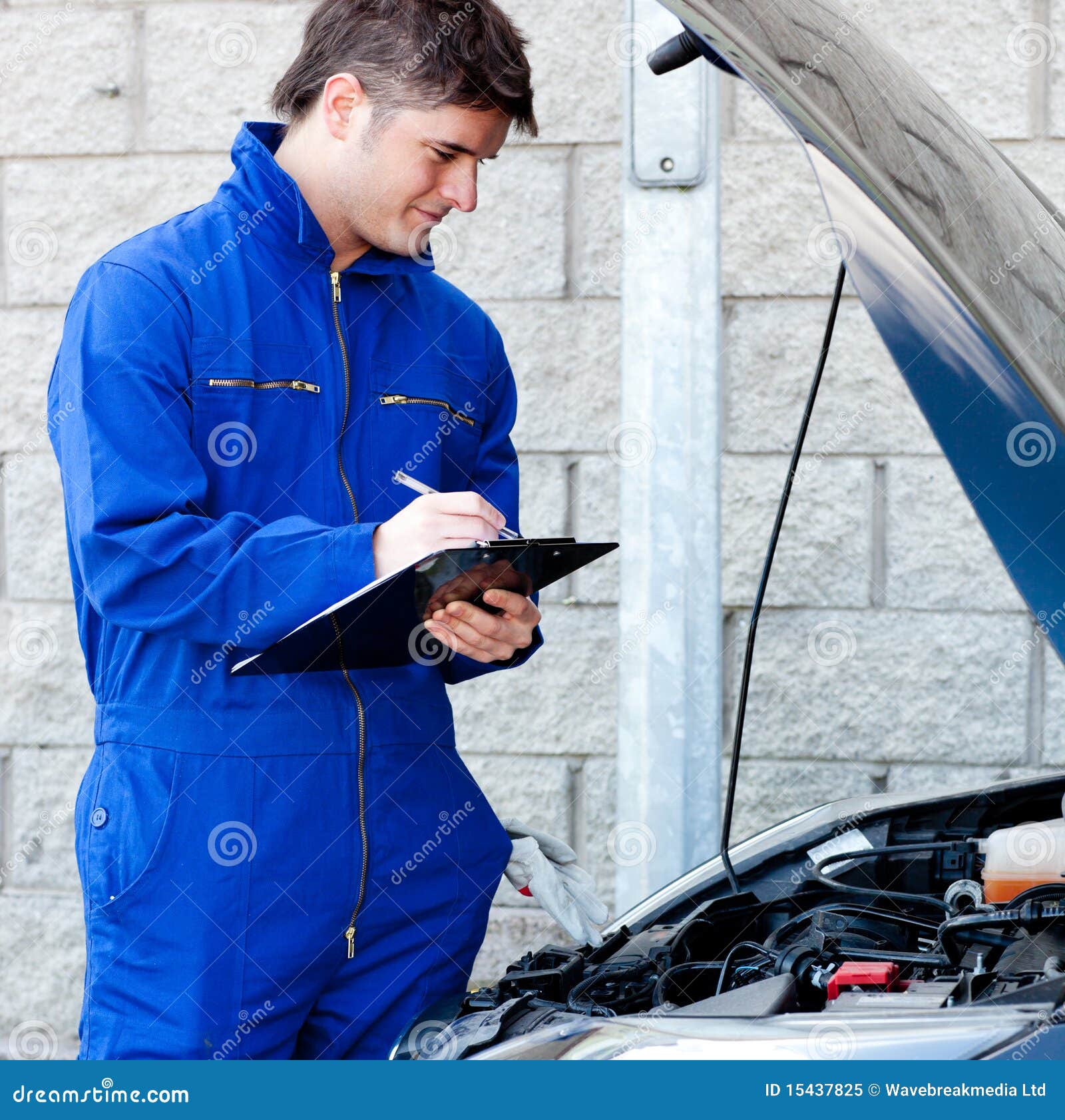 Handsome Mechanic Writing On A Clipboard Royalty Free Stock Photo ...