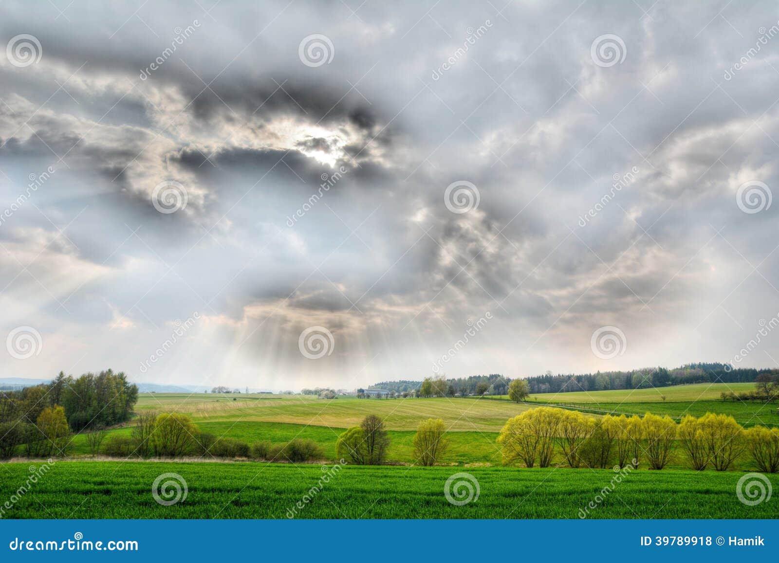 Nature panorama with shining sun behind the clouds. HDR effect.