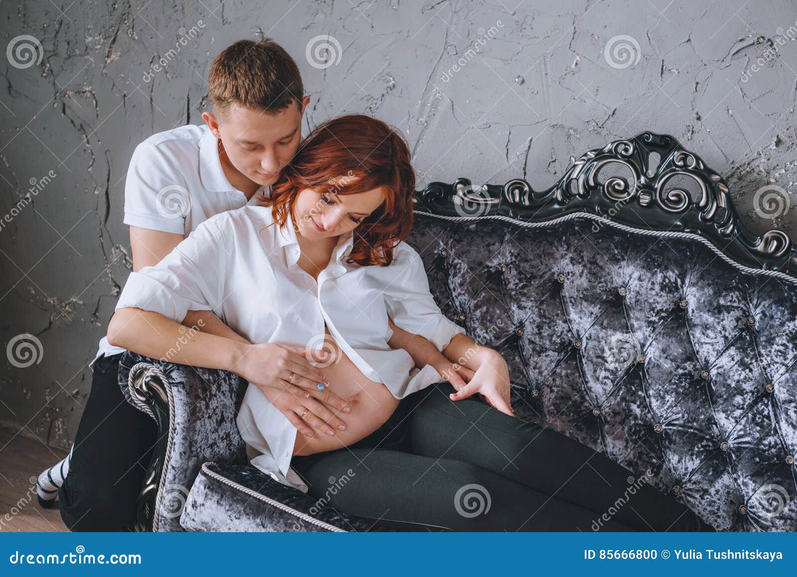 Her Husband Hugging Pregnant Woman On A Gray Sofa Looking At Pregnant Naked Belly Stock Photo 108717 Hot Sex Picture image