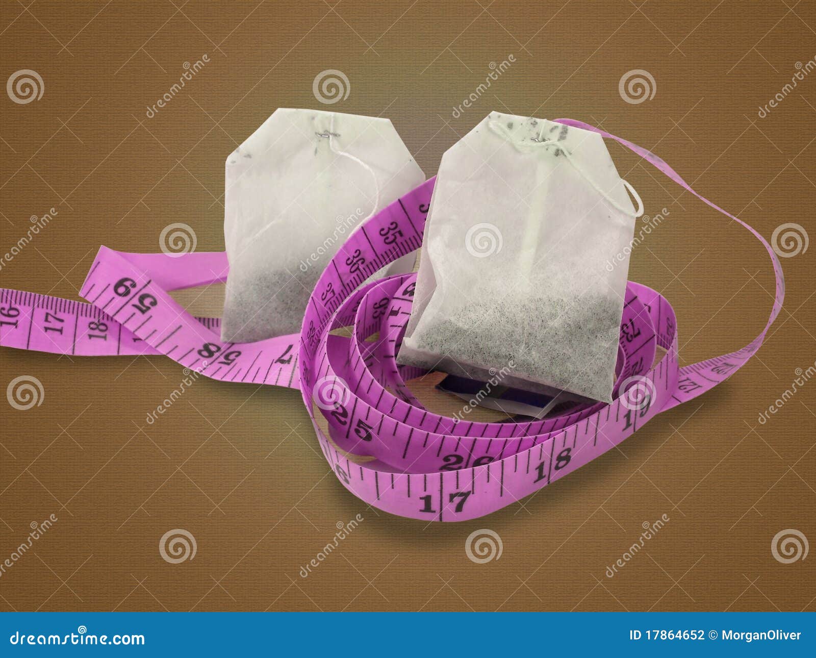 Two Herbal Tea Bags Nestled On Top Of A Pink Measuring Tape Isolated