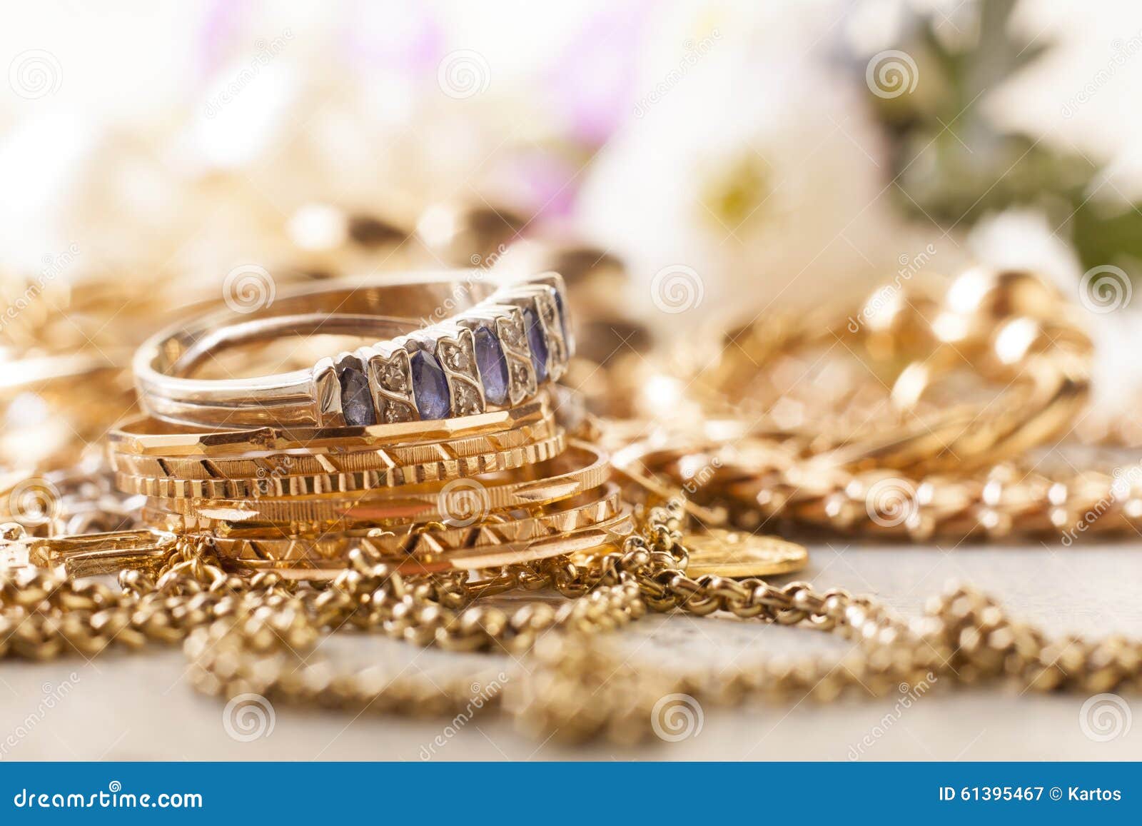 Shiny gold and silver jewelery on white table.