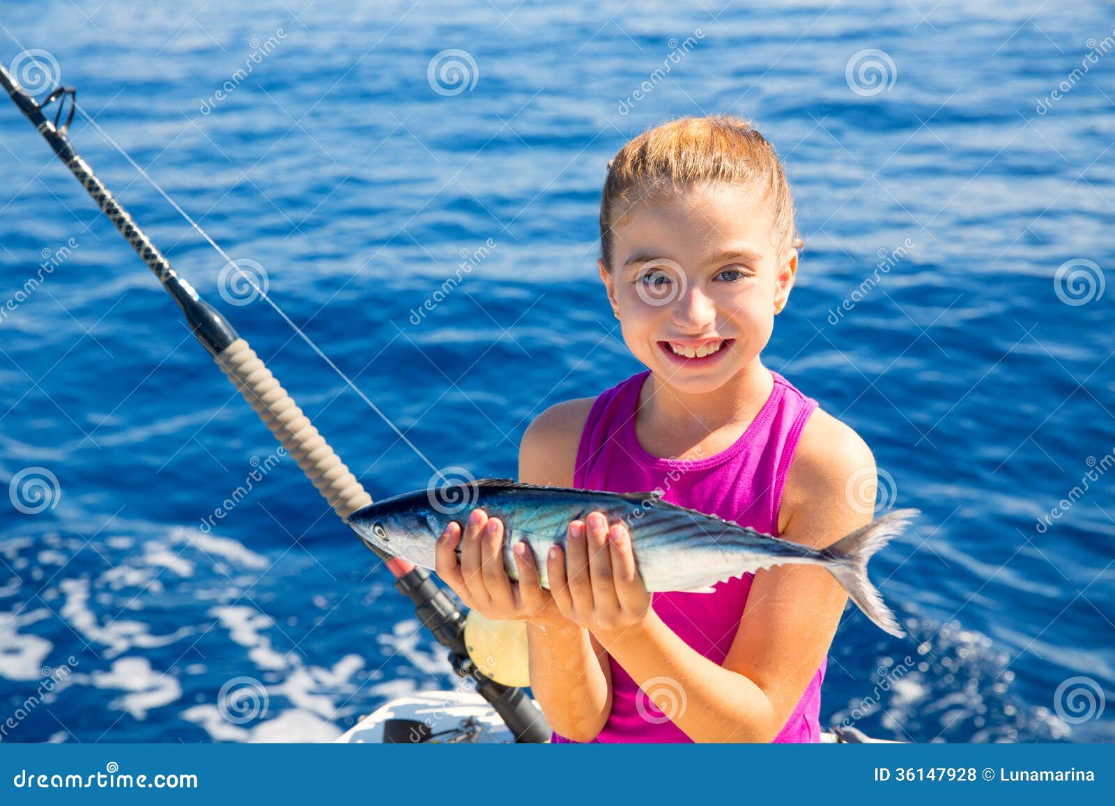  Stock Photos: Kid girl fishing tuna bonito sarda fish happy with catch