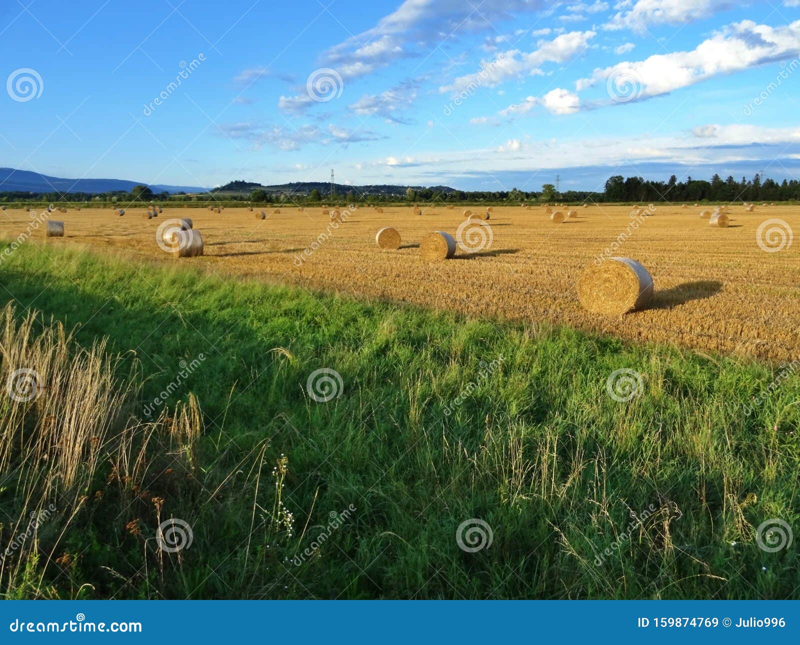 Landscape Of Wheat Field After Harvest With Straw Bales At Sunset Stock