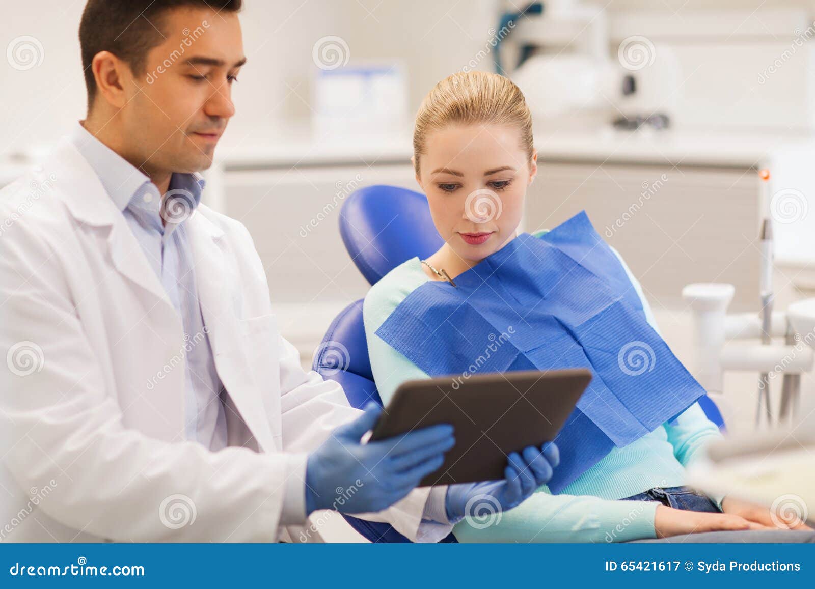  health care concept  male dentist showing tablet pc computer to women