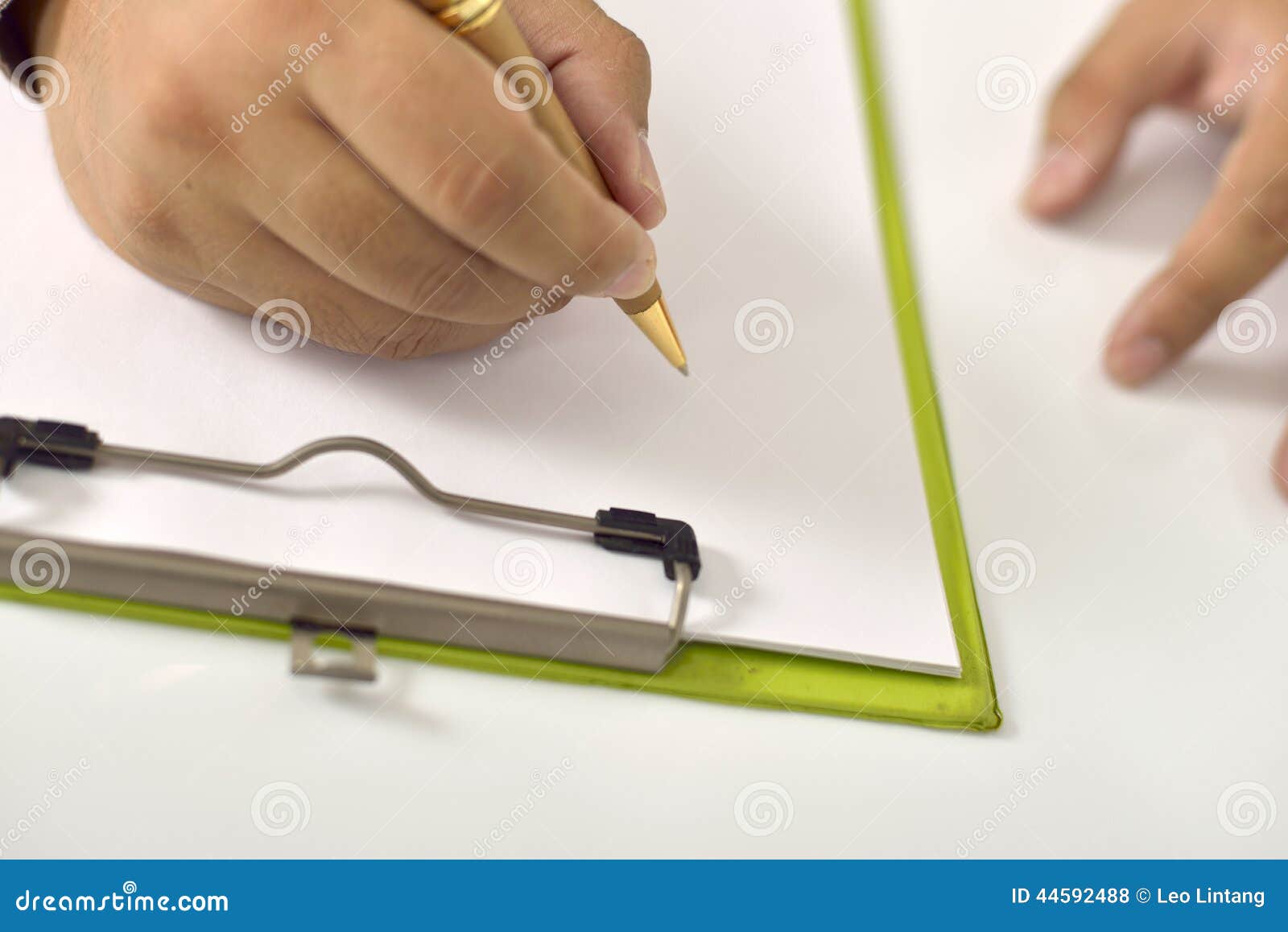 Man writing on blank paper on clipboard. You can put your design on it ...