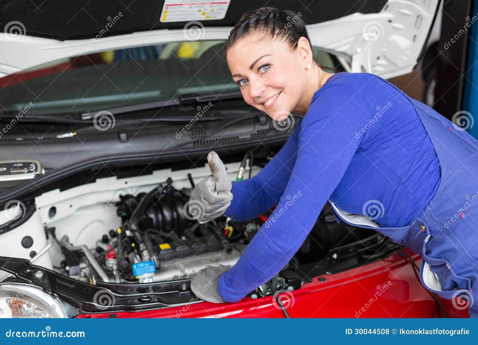 mechanic repairing the motor or electric parts of a car in a garage mr ...