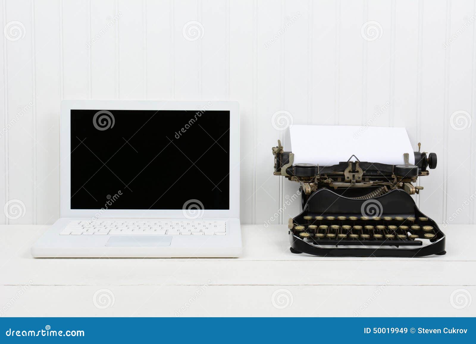 modern laptop antique typewriter closeup white desk computer horizontal format copy space old vs new 50019949