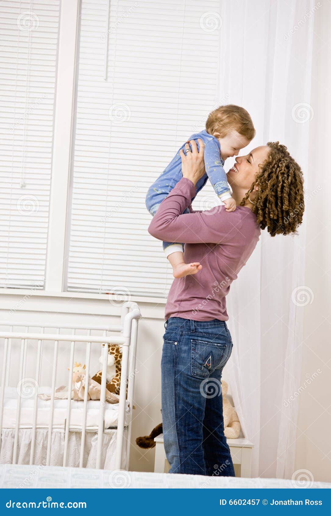 Mother Lifting Son From Crib In Bedroom Royalty Free Stock Photography ...