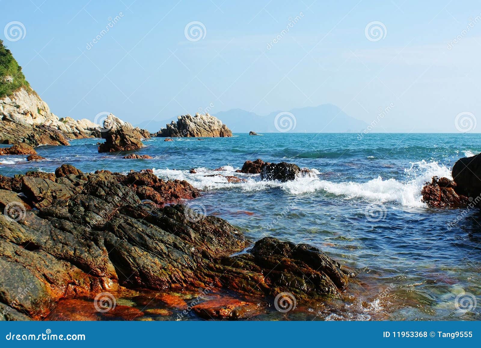 The beautiful coastline and distant blue mountains.