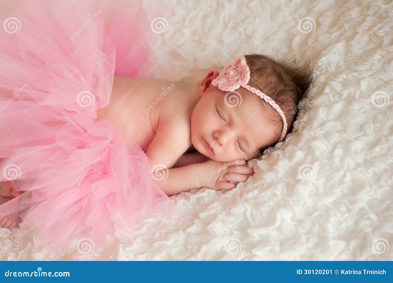 705 New baby headband subscription 433 Newborn baby girl wearing a pink crocheted headband and tutu. She is   