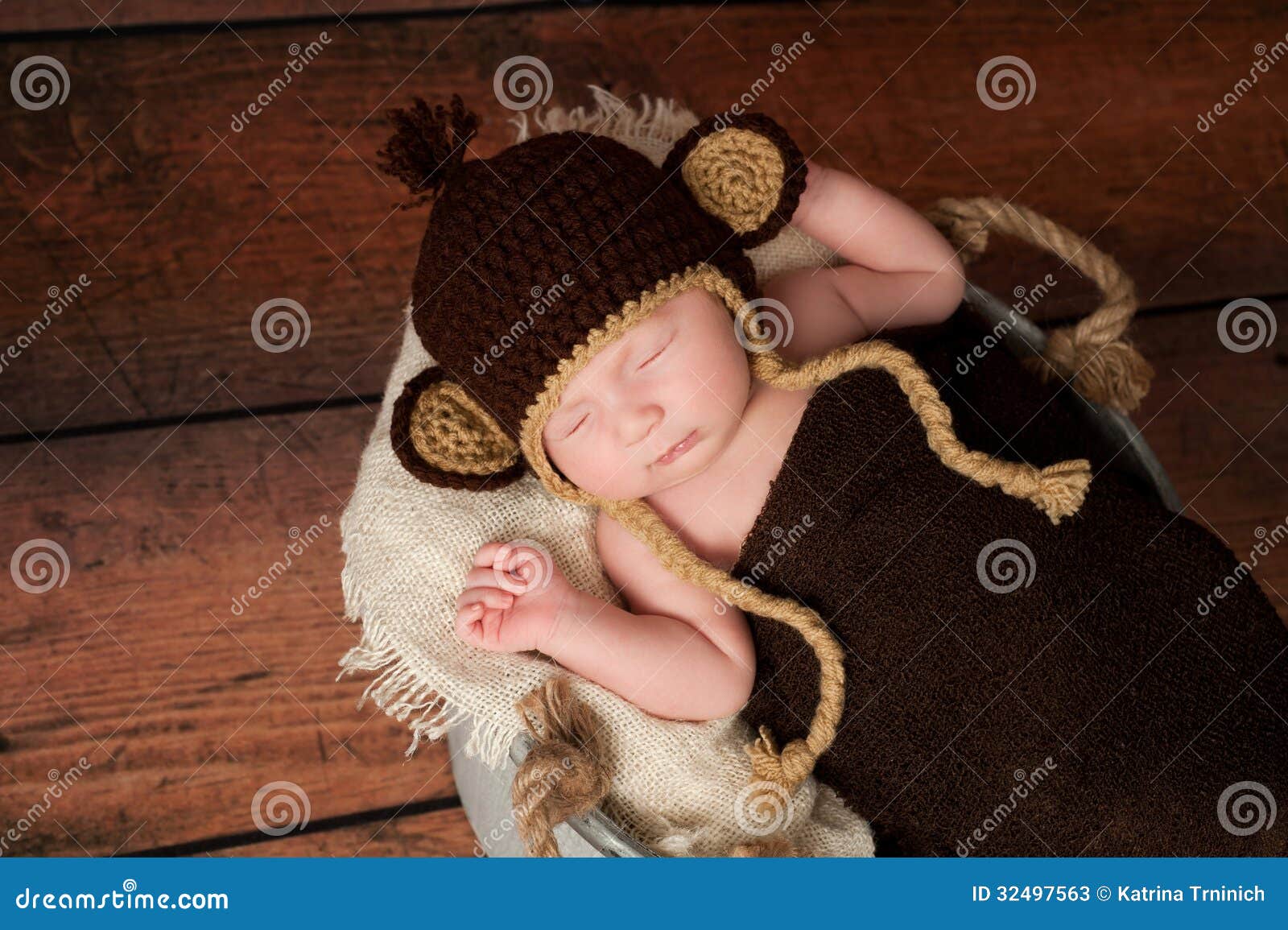  - newborn-baby-wearing-monkey-hat-crocheted-sleeping-galvanized-bucket-shot-studio-rustic-wood-background-32497563