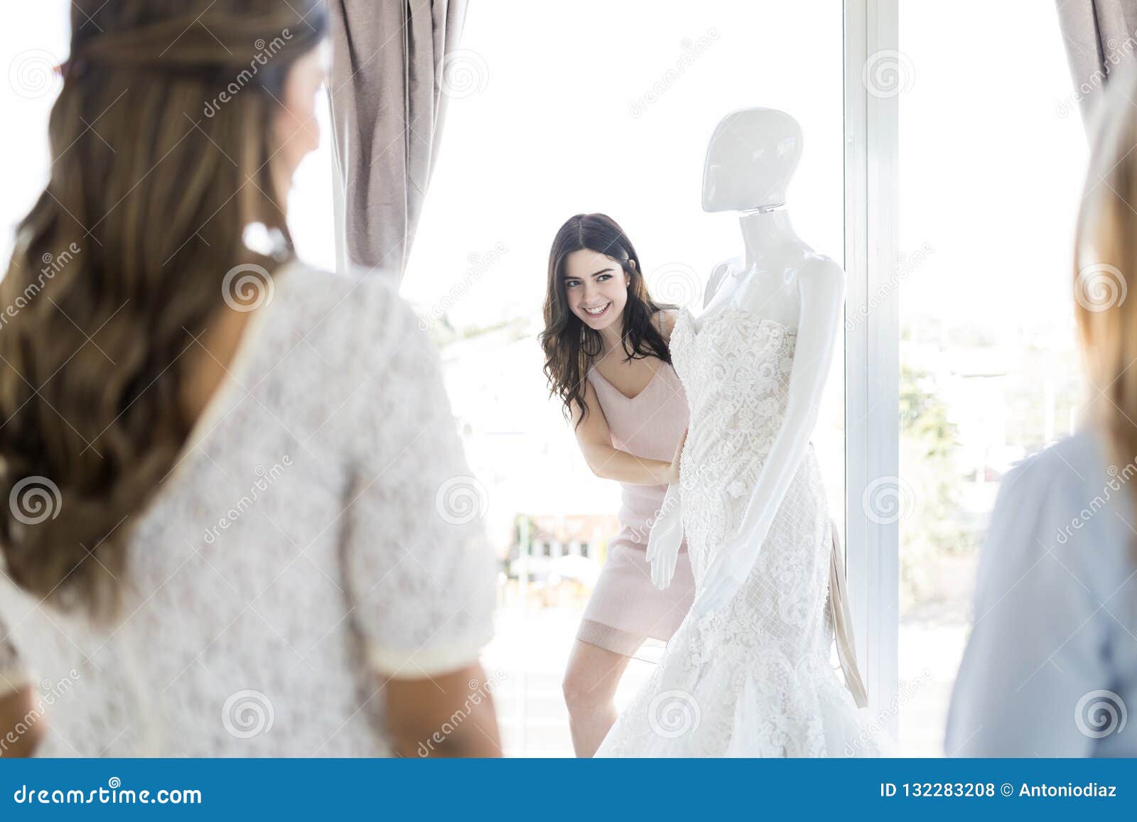 Noiva Que Olha Amigos Ao Estar Pelo Manequim Na Loja Foto De Stock