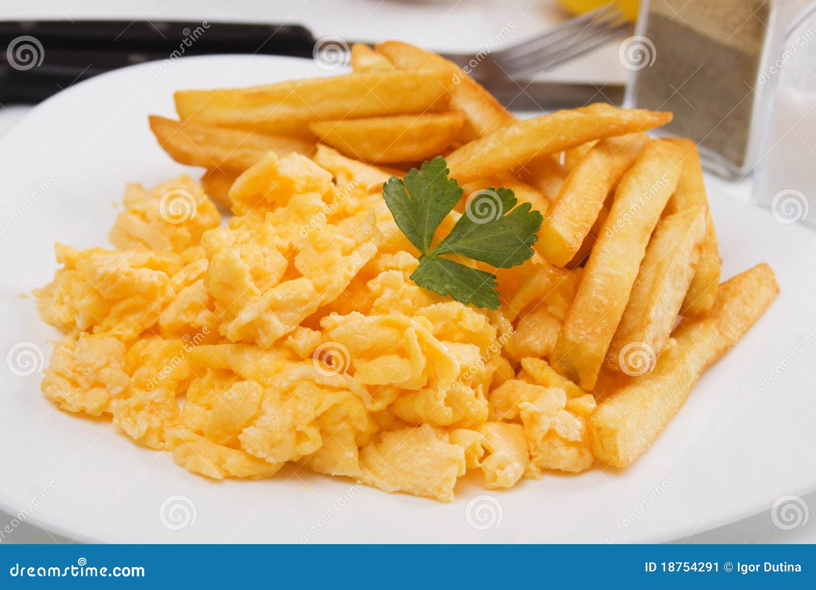 Oeufs brouillÃ©s avec des pommes frites de la plaque blanche.