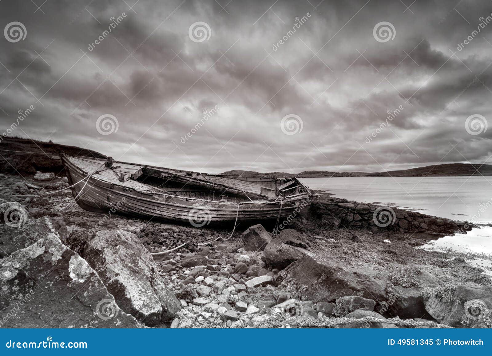 Weathered fishing boat lying on a rocky beach on the Isle of Lewis ...