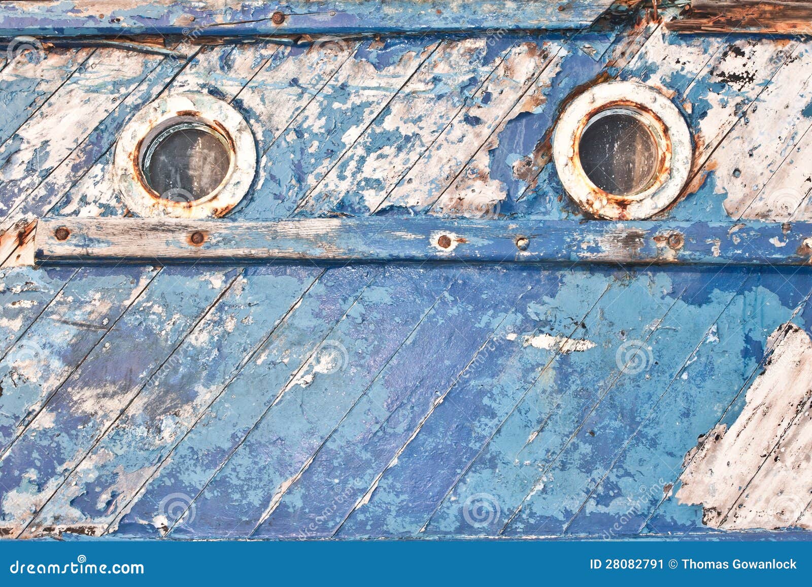 Close up of the portholes on the side of an old fishing boat.