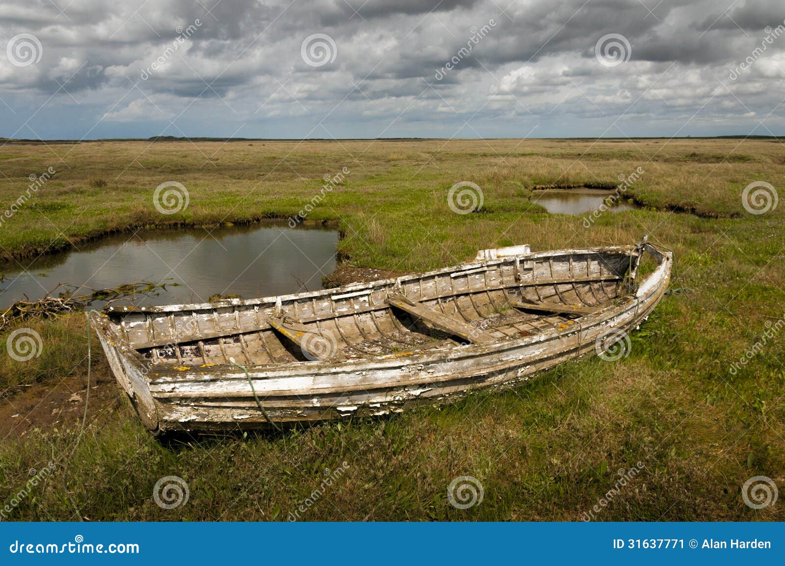 Old rotting wooden rowing boat at Brancaster Norfolk England.