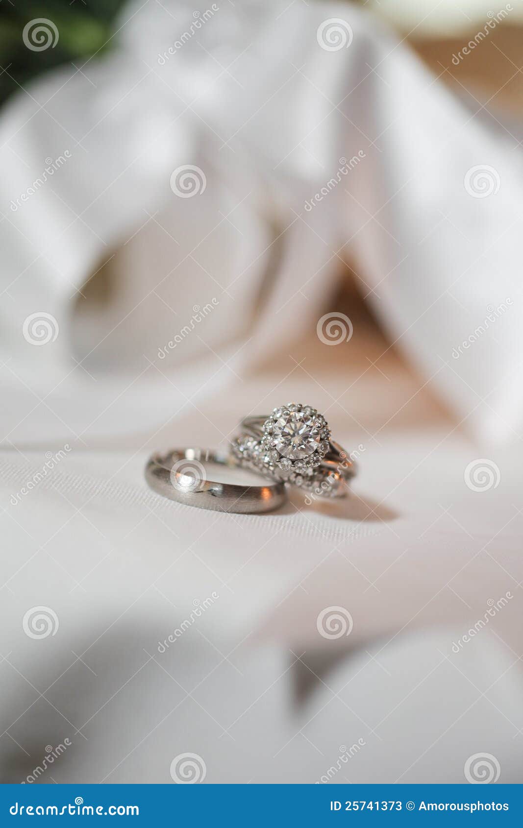 Pair of silver wedding rings with white background.