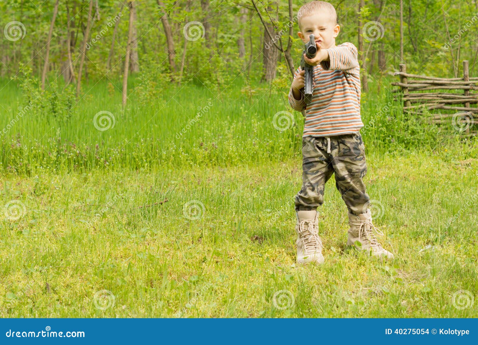 http://thumbs.dreamstime.com/z/petit-gar%C3%A7on-dirigeant-une-arme-automatique-40275054.jpg