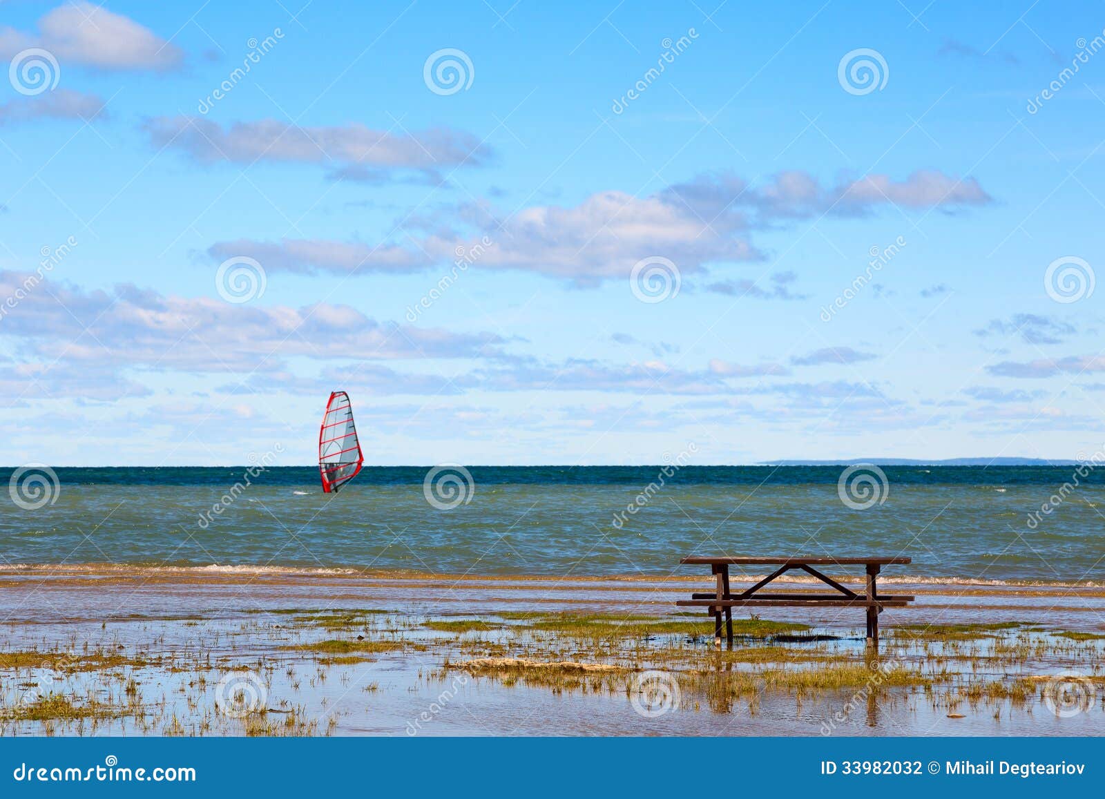 Picnic table on a lake shore with legs slightly flooded by shallow 