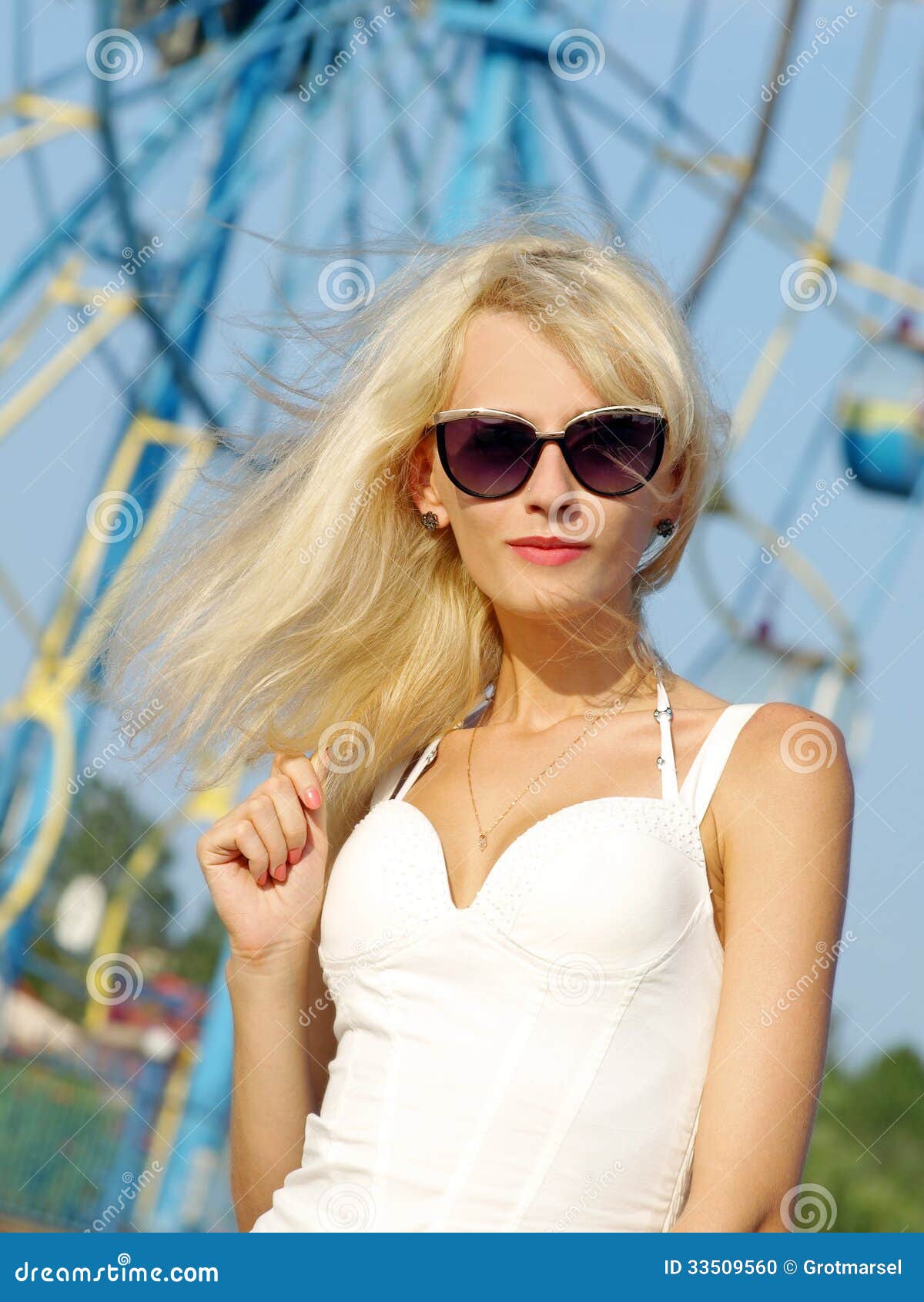 Pretty Blonde With Sun Glasses Against Carousel Stock